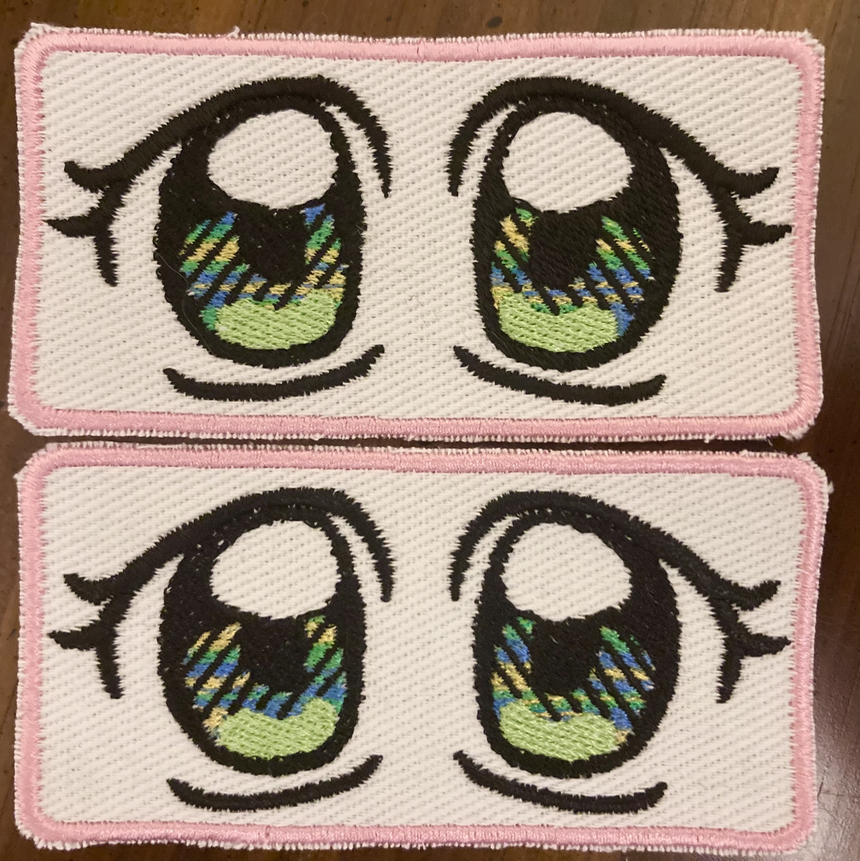 A photograph of two 90's moe eyes embroidered patches